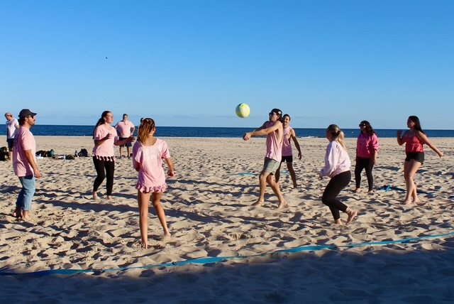 The pink team lunges for a dig