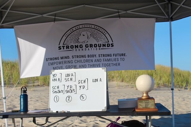 The bracket board and trophies under the tent
