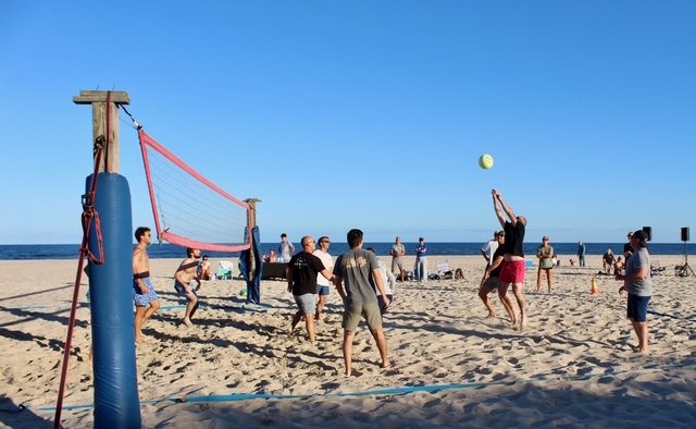 A dig at the net with the crowd watching from the sand